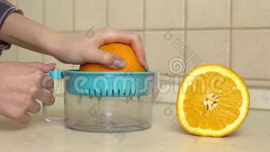 一个女人从橘子里榨果汁。 女人用榨汁机。 把手举起来。